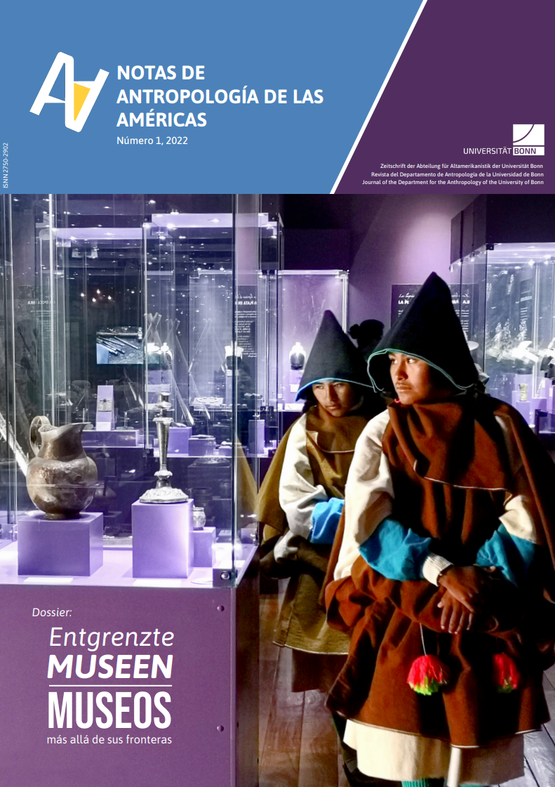 Two people in traditional clothing stand inside a museum gallery with purple-lit glass display cases exhibiting pre-Columbian ceramic and metal artifacts.